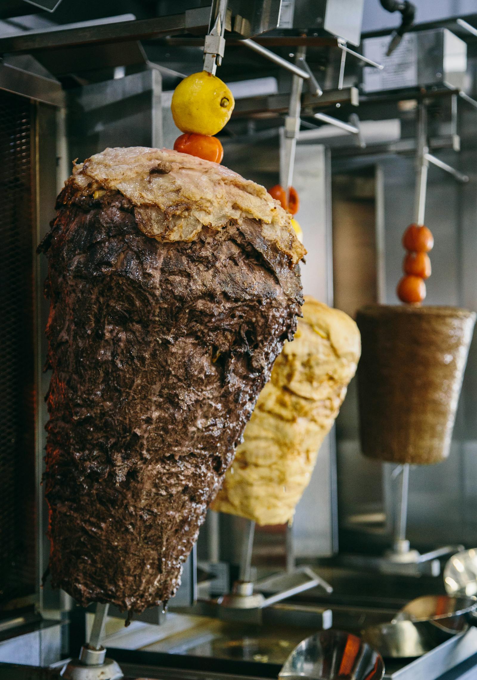 Seasoned shawarma roasting on a vertical spit in the Mission Valley kitchen